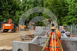 Surveyor site engineer with total positioning station on the construction site of the new road construction with construction