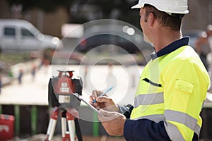 surveyor on site writing on clipboard photo