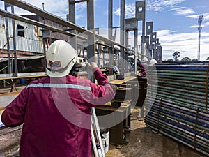 Surveyor is using the surveyor& x27;s telescope to check the level of bottom steel plate of steel structure work