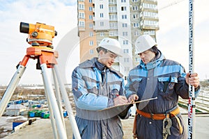 Surveyor workers with level at construction site