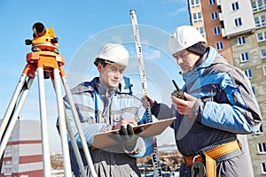 Surveyor workers with level at construction site