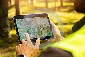 Surveyor working with forest topography map in digital tablet. land surveying photo