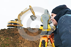 Surveyor works with theodolite photo