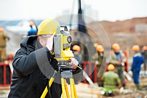 Surveyor works with theodolite photo