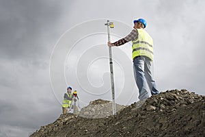 Surveyors using theodolite on building site