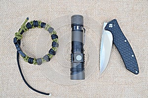 Survival kit. Folding knife, flashlight and paracord bracelet