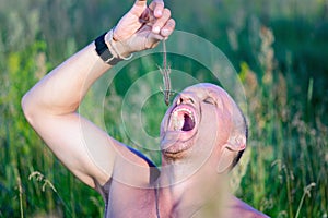 Survival in the wild. Hungry man wants to eat a lizard.