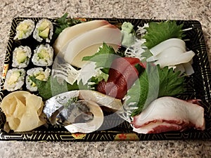 sushi with avocado roll and raw fish in container