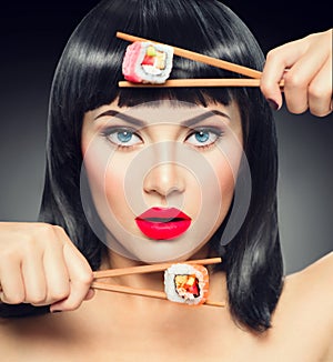 Sushi. Beauty model girl eating sushi rolls