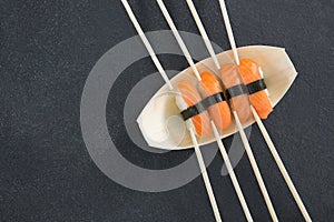 Sushi on boat shaped plate with chopsticks