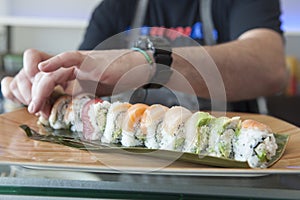 Sushi chef plating a roll of sushi
