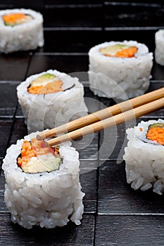 Sushi with chopsticks on back wood