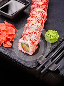 Sushi with chopsticks, ginger, soy sauce and wasabi. Japanese food. Set of sushi roll with vegetables, fish and caviar