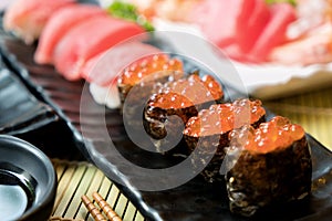 Sushi with chopsticks and soy sauce. Sushi roll japanese food in restaurant. Salmon roe Sushi set with salmon, vegetables, flying