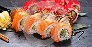 Sushi with chopsticks. Sushi roll japanese food in restaurant. California Sushi roll set with salmon, vegetables