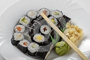 Sushi dish of traditional Japanese cuisine on a white plate, top view