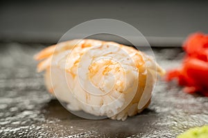 Sushi Ebi Nigiri with prawn on a dark stone background, close-up.