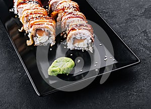 Sushi eel roll maki on black plate