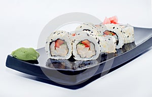 Sushi with ginger and wasabi on a black plate