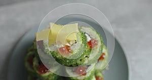 Sushi with green flying fish caviar is laid out on a plate in a slide with a cheese star at the top. Macro shooting
