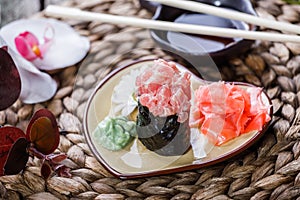 Sushi Gunkan maki with salmon on plate on bamboo mat, selective focus. Japanese cuisine.