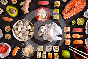 Sushi and ingredients on dark background