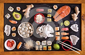 Sushi and ingredients on dark background