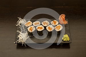 Norwegian salmon maki sushi with nori seaweed rolled rice. Rice and wasabi fieos with ginseng photo