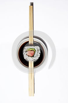 Sushi maki roll with chopsticks and soy sauce