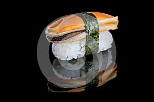 Sushi nigiri with mussel on black background with reflection. Ja