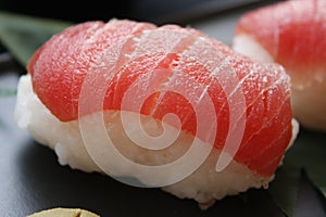 Sushi nigiri with rice and neta topping salmon fish on black background. photo