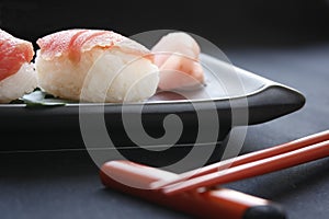 Sushi nigiri with rice and neta topping salmon fish on black background. photo