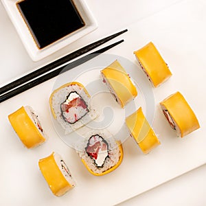 Sushi plate on white background, rolls set with cheese and tuna fish on white background from above. Top view of