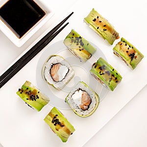Sushi plate on white background, rolls set with cucumber on white background from above. Top view of traditional