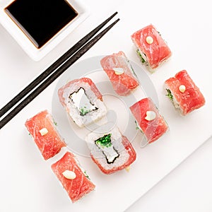 Sushi plate on white background, rolls set with red tobiko egg on white background from above. Top view of traditional