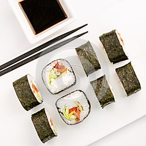Sushi plate on white background, rolls set with vegetables on white background from above. Top view of traditional