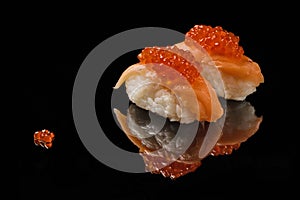 Sushi and red caviar on black acryle photo