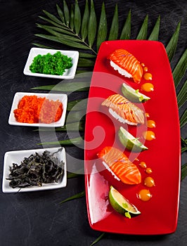 Sushi on red plate served with lime