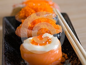 Sushi rice wrapped in seaweed and shrimp egg with chopstick