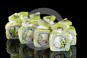 Sushi Roll with crab meat, kiwi and avocado over black backgrou