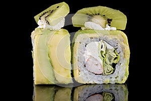 Sushi Roll with crab meat, kiwi and avocado over black backgrou