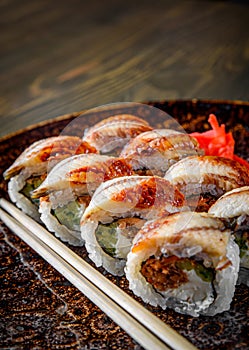 Sushi roll with cream cheese and eel in plate on wooden table