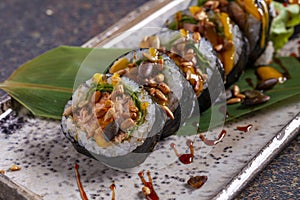 Sushi roll with eel, cucumber and sesame seeds