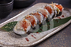 Sushi roll with eel, cucumber and sesame seeds