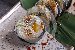 Sushi roll with eel, nori, cucumber and sesame seeds