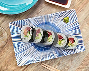 Sushi roll futomaki with cucumber, avocado, tuna, surimi, salad and salmon