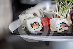 Sushi roll japanese food on black plate. Sushi roll set with salmon, caviar rice and vegetables. Japan restaurant menu