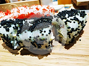 Sushi roll japanese food in restaurant. California Sushi roll set with salmon, vegetables, flying fish roe and caviar closeup