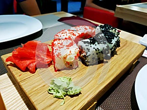 Sushi roll japanese food in restaurant. California Sushi roll set with salmon, vegetables, flying fish roe and caviar closeup