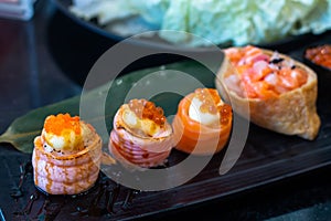 Sushi roll japanese food in restaurant. with salmon, vegetables, flying fish roe and caviar closeup.